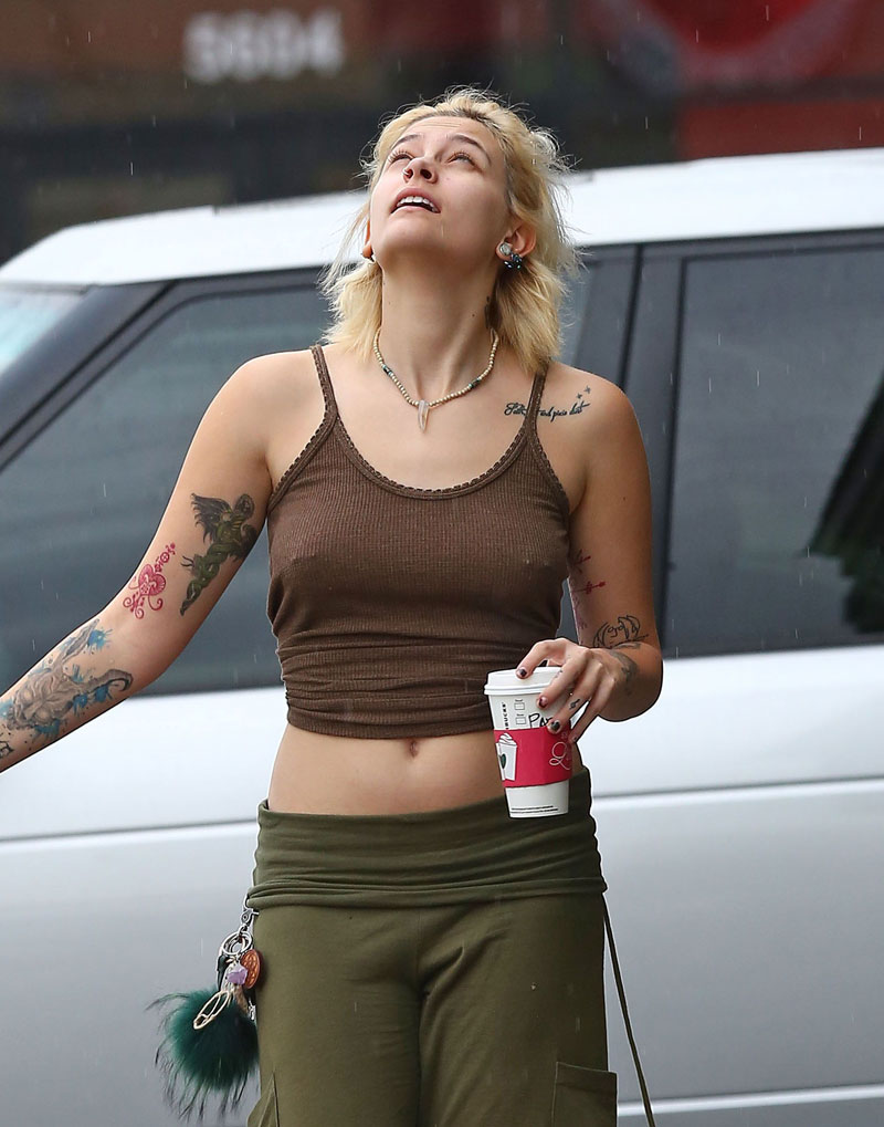 Paris Jackson enjoys the rain while braless in a tight brown top that shows...