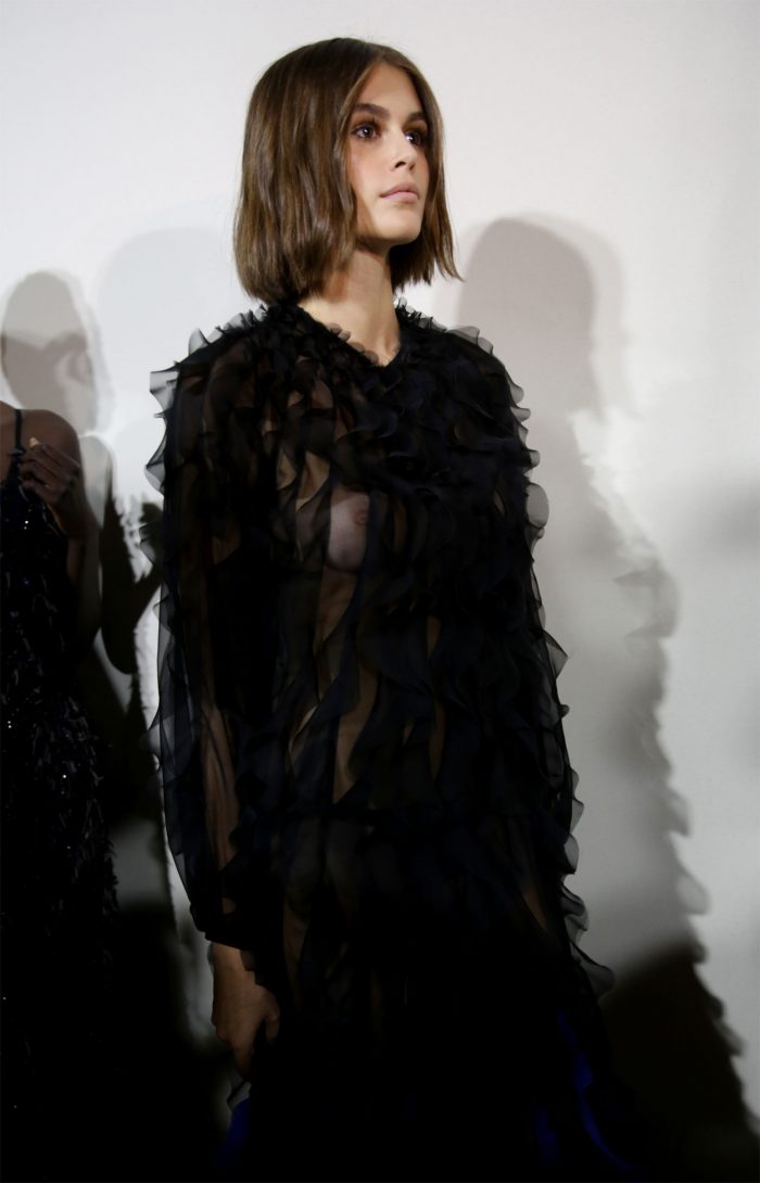 Kaia Gerber Braless Breasts in Black Lace Dress at a Fashion Show